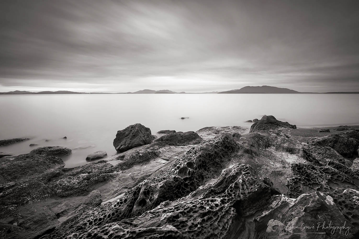 Tafoni formations in sandstone rock at Clayton Beach, Larrabee State Park Washington. Samish Bay and the San Juan islands can be seen in the distance. #56458bw