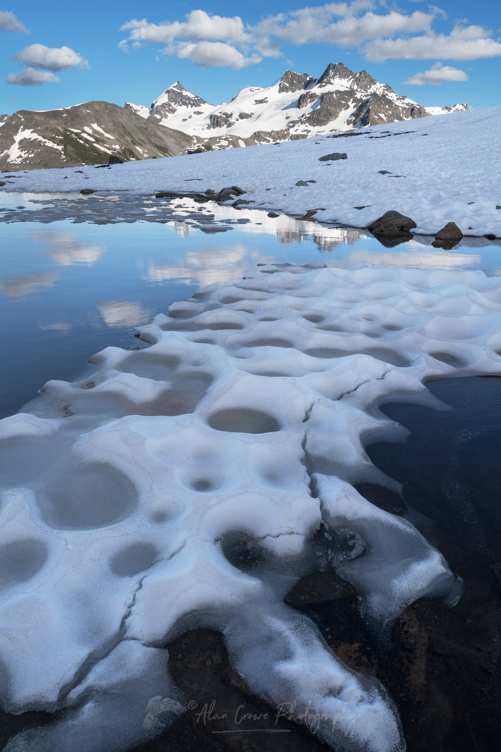 Snow melt tarn on Silent Mountain. Twin Towers, Cony Peak, and Spillimacheen Glacier are in the distance. Purcell Mountains, British Columbia #86137